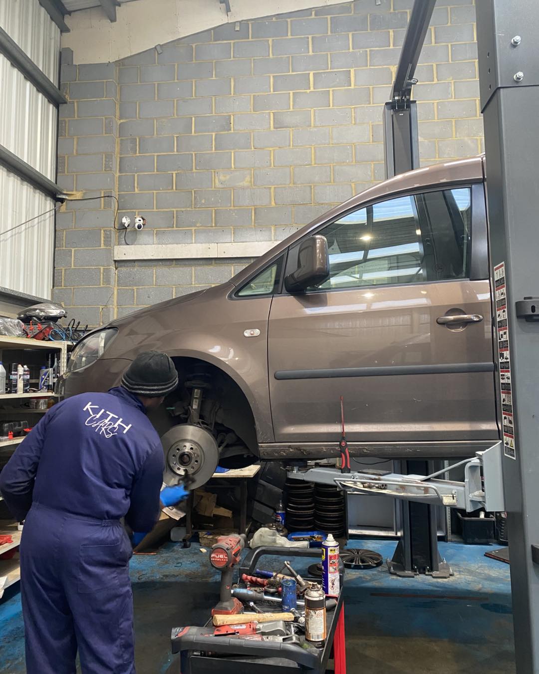 KITH Cars Garage technician working on vehicle brakes